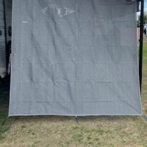 A Pop Top privacy screen end wall / side sun shade is being used as a privacy screen next to an RV.