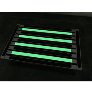 An Illuminating extra large platform portable folding step with green strips on it.