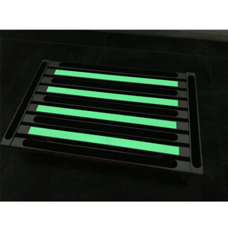 An Illuminating extra large platform portable folding step with green strips on it.