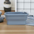 A Set of 4 Collapsible Food Containers (PRE ORDER LISTING – DISPATCH DATE 1st MAY) on a wooden kitchen counter, with their transparent lids partially open and additional containers in the background.